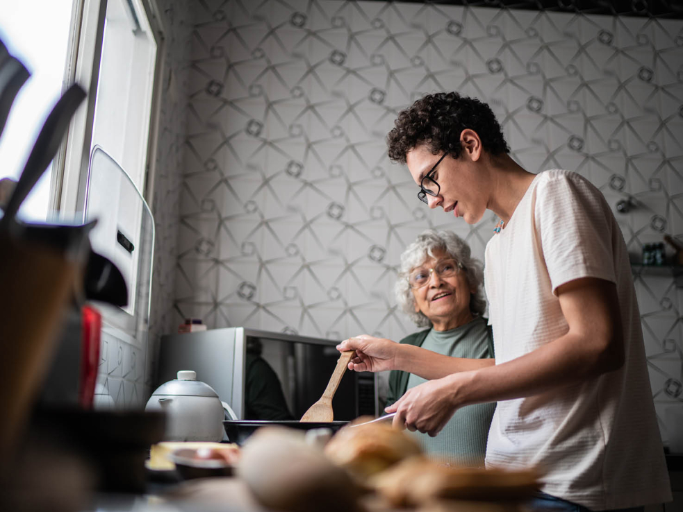 Grossmutter gibt Enkel Tipps beim Kochen.